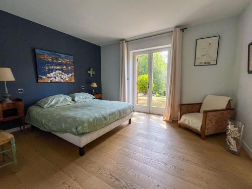 une chambre avec un lit, une fenêtre et une chaise dans l'établissement Les champs d'Hermier avec Piscine, à Carsac-Aillac