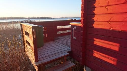 a wooden deck with a bench next to a body of water at Muskö Havsbad in Muskö Havsbad