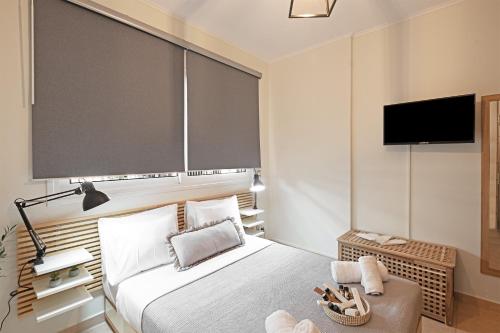 a bedroom with a bed and a flat screen tv at Xenia Serenity in Kalamata