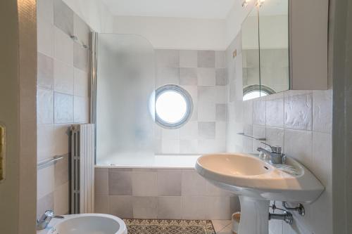 a bathroom with a sink and a toilet and a mirror at La Torre dell'Isola in Sala Comacina