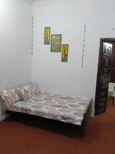 a bed in a room with pictures on the wall at Shukla home stay in Jabalpur