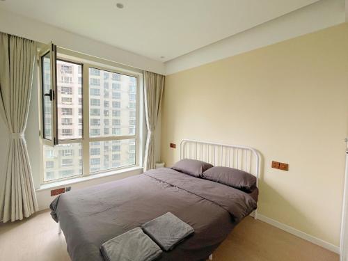 a bedroom with a bed and a large window at Pure Home-Near the Bund enjoys the beautiful scenery of the Bund 3-bedhome close to Yuyuan Garden Huaihai Road and Nanjing Road Pedestrian Street in Shanghai