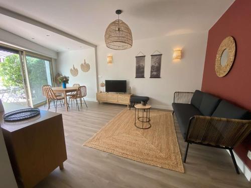 un salon avec un canapé et une table dans l'établissement Le charme de Sanary Portissol à 100 m de la plage, Jardin, garage, climatisation..., à Sanary-sur-Mer
