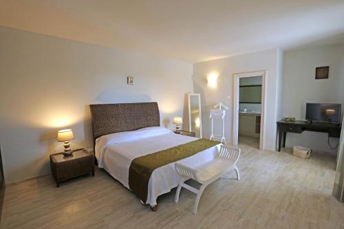 een slaapkamer met een bed, een stoel en een bureau bij La Vigna in Leverano