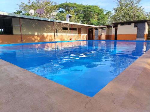 a pool with blue water in front of a building at Hotel El Cocobolo Food&Rest Room 3 B&B WiFi AC Pkg Free Swimmingpool in Liberia