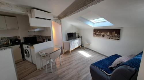 un salon avec un canapé et une cuisine dans l'établissement Joli 2 pièces rénové à proximité du centre et plage, à Cannes