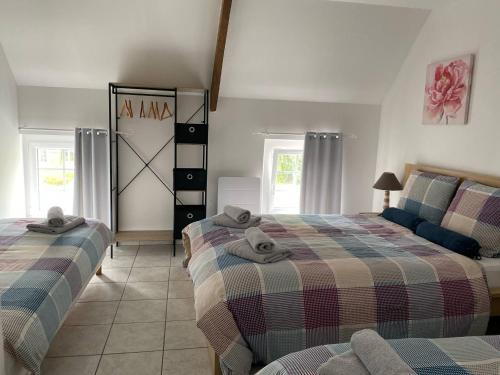 une chambre avec deux lits et un canapé dans l'établissement Appartement 1 chambre et cuisine VIERVILLE-SUR-MER,plage du Débarquement, à Vierville-sur-Mer