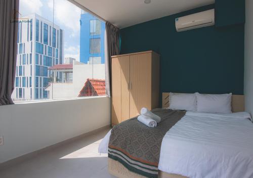a bedroom with a large bed with a large window at Lumina Home in Ho Chi Minh City