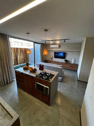 a kitchen with a stove and a living room at Casa Villa Kamai 01 in São Miguel dos Milagres