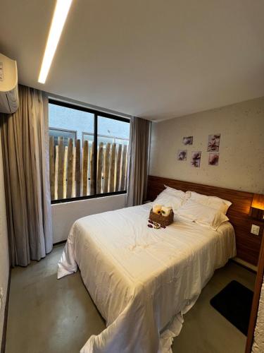 a bedroom with a large bed with a teddy bear on it at Casa Villa Kamai 01 in São Miguel dos Milagres