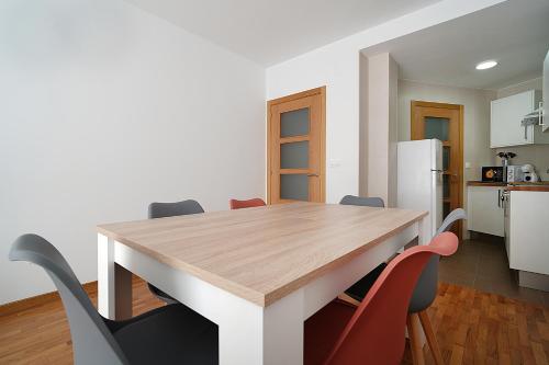 a kitchen and dining room with a wooden table and chairs at Apartamento con vistas al mar en Raxó in Raxo