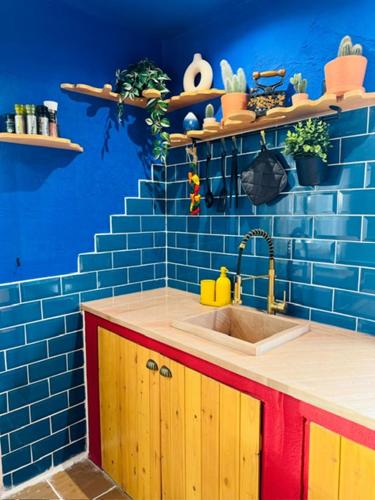 a kitchen with a sink and a blue wall at Mexican House in Cortesia
