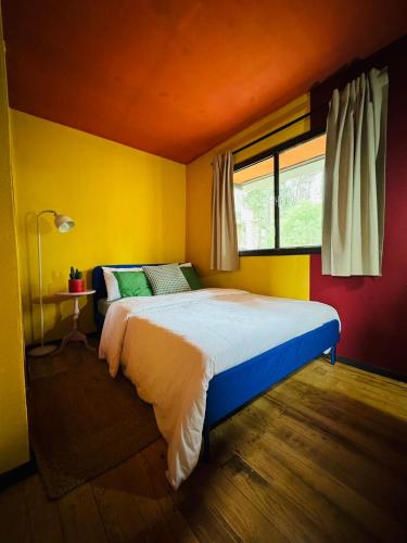 a bedroom with a bed in a yellow room at Mexican House in Cortesia