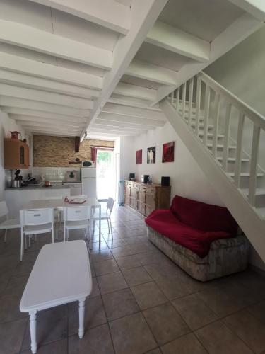 a living room with a couch and a staircase at Le Coquelicot in Fajoles
