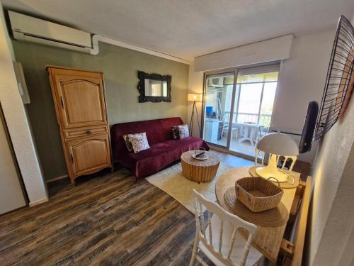 un salon avec un canapé rouge et une table dans l'établissement Le Lagon Bleu - Piscine, à Fréjus