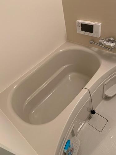 a white bath tub in a bathroom with a plug at Camper in Kumamoto