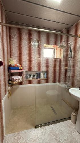 a bathroom with a glass shower and a sink at Apartament in Kobuleti in K'obulet'i