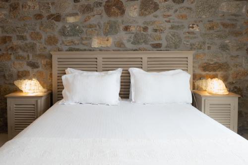 a bedroom with a white bed with two night stands at The Summit of Mykonos in Kalo Livadi