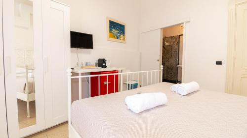 a bedroom with two beds and a small kitchen at Affittacamere Juighissa Leonora in Oristano