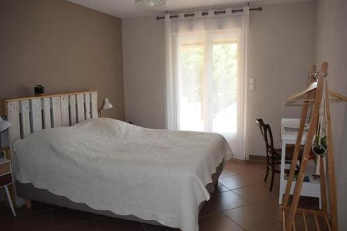 une chambre avec un lit, un bureau et une fenêtre dans l'établissement Chambre la canauloise, à Canaules-et-Argentières