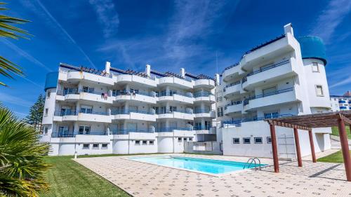a large white building with a swimming pool in front of it at Marquinhos do Mar by AcasaDasCasas in Ericeira