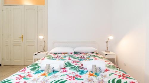 a bedroom with a bed with a floral bedspread at Affittacamere Juighissa Leonora in Oristano