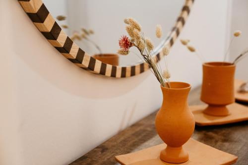 three vases sitting on a table with flowers in them at Hotel Bleu Soleil in Capbreton