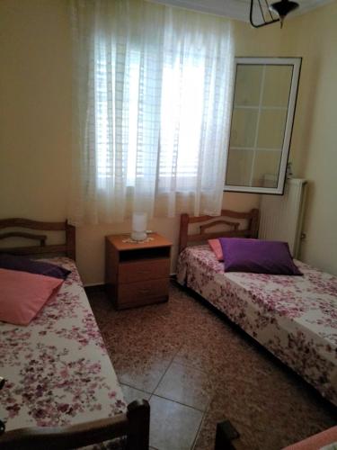 two beds sitting in a room with a window at Katerina in Ormos Panagias