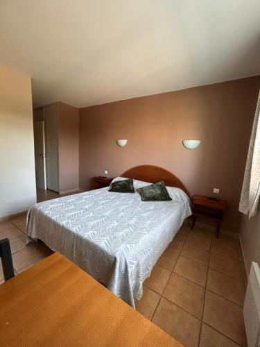 Les Oliviers في مونتانياك: غرفة نوم بها سرير ووسادتين عليه