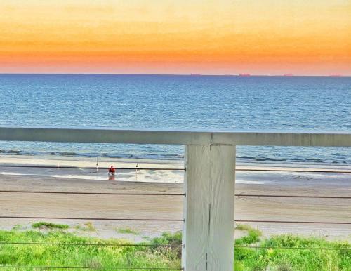 a view of the ocean from a fence at the beach at Beachfront - Hot Tub - Home Theater in Bolivar Peninsula