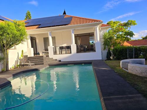 a house with a swimming pool in front of a house at Die Regte Rede in Cape Town