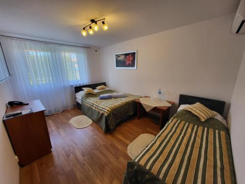 a small room with two beds and a table at Willa Biały Dom - Aquapark Panorama Morska All Inclusive in Jarosławiec