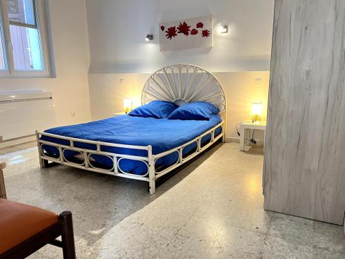 une chambre avec un grand lit avec des oreillers bleus dans l'établissement Between Land and Sea, à Hyères