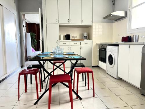 une cuisine avec une table et quatre tabourets rouges dans l'établissement Between Land and Sea, à Hyères