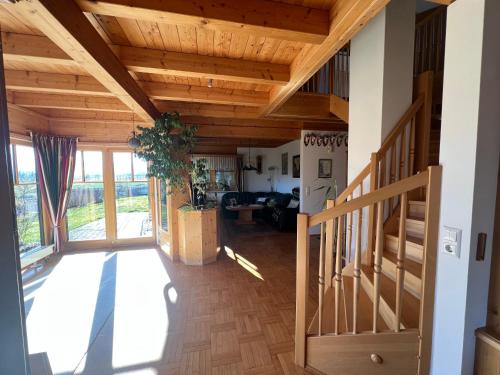 a living room with wooden ceilings and a staircase at Haus am Ring in Spielberg