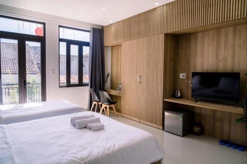 a bedroom with a bed and a flat screen tv at Tự Do Homestay Huế in Hue