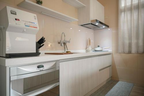 a white kitchen with a sink and a stove at Lee Home 李寓-恆春的家包棟民宿-墾丁 in Hengchun