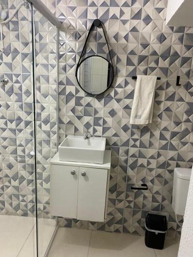 a bathroom with a sink and a mirror at Pousada do sol in Sorocaba