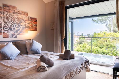 a bedroom with a bed and a large window at L'ESCALE COTE BLEUE VILLA & Spa Classée 4 Étoiles in Sausset-les-Pins