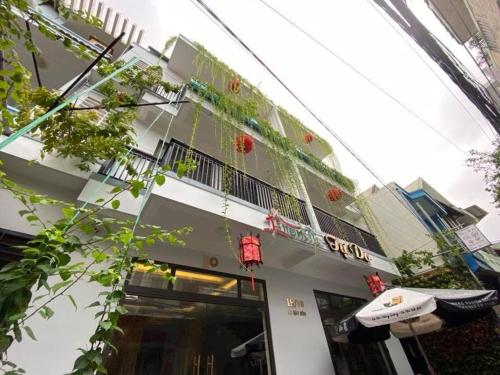 ein weißes Gebäude mit einem Balkon und einem Sonnenschirm in der Unterkunft Tự Do Homestay Huế in Hue