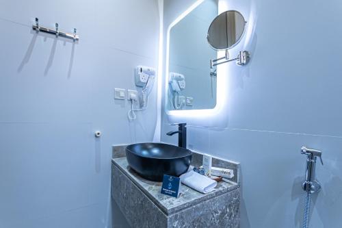 a bathroom with a sink and a mirror at Land Walk Hotel Al Taawun Riyadh in Riyadh