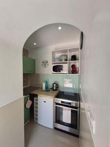une petite cuisine avec une arche au-dessus d'un poêle dans l'établissement Cozy Studio in Cannes, à Cannes