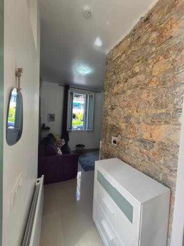 - un salon avec un mur en pierre et un canapé dans l'établissement Cozy Studio in Cannes, à Cannes