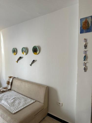a living room with a couch against a white wall at Des appartements a la Marsa plage Pieds dans l'eau in Dar Salah Bey