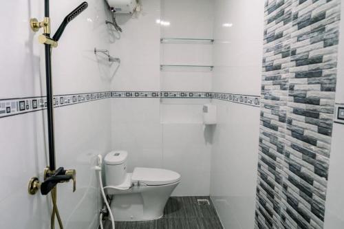 ein weißes Badezimmer mit Toilette und Dusche in der Unterkunft Tự Do Homestay Huế in Hue