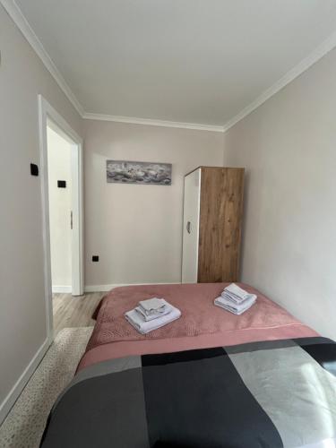 a bedroom with a bed with two towels on it at Apartmani Djordjevic in Belgrade