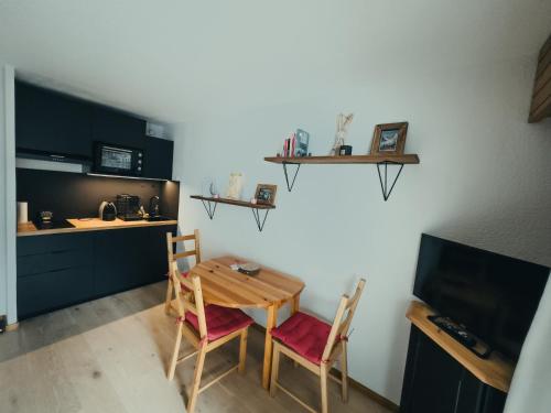 une cuisine avec une table et deux chaises ainsi qu'une télévision dans l'établissement Le Montenvers - Central Studio & Private parking, à Chamonix-Mont-Blanc