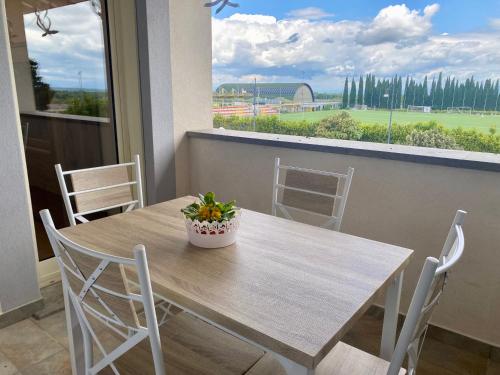 a wooden table with chairs and a potted plant on it at Appartamento in centro paese in Monterosi
