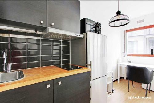 une cuisine avec un réfrigérateur en acier inoxydable et un évier dans l'établissement Cosy studio - 2P - Trocadero, à Paris