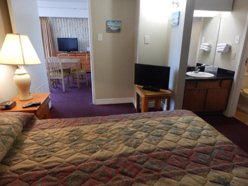 a hotel room with a bed and a bathroom at Padre South Hotel On The Beach in South Padre Island